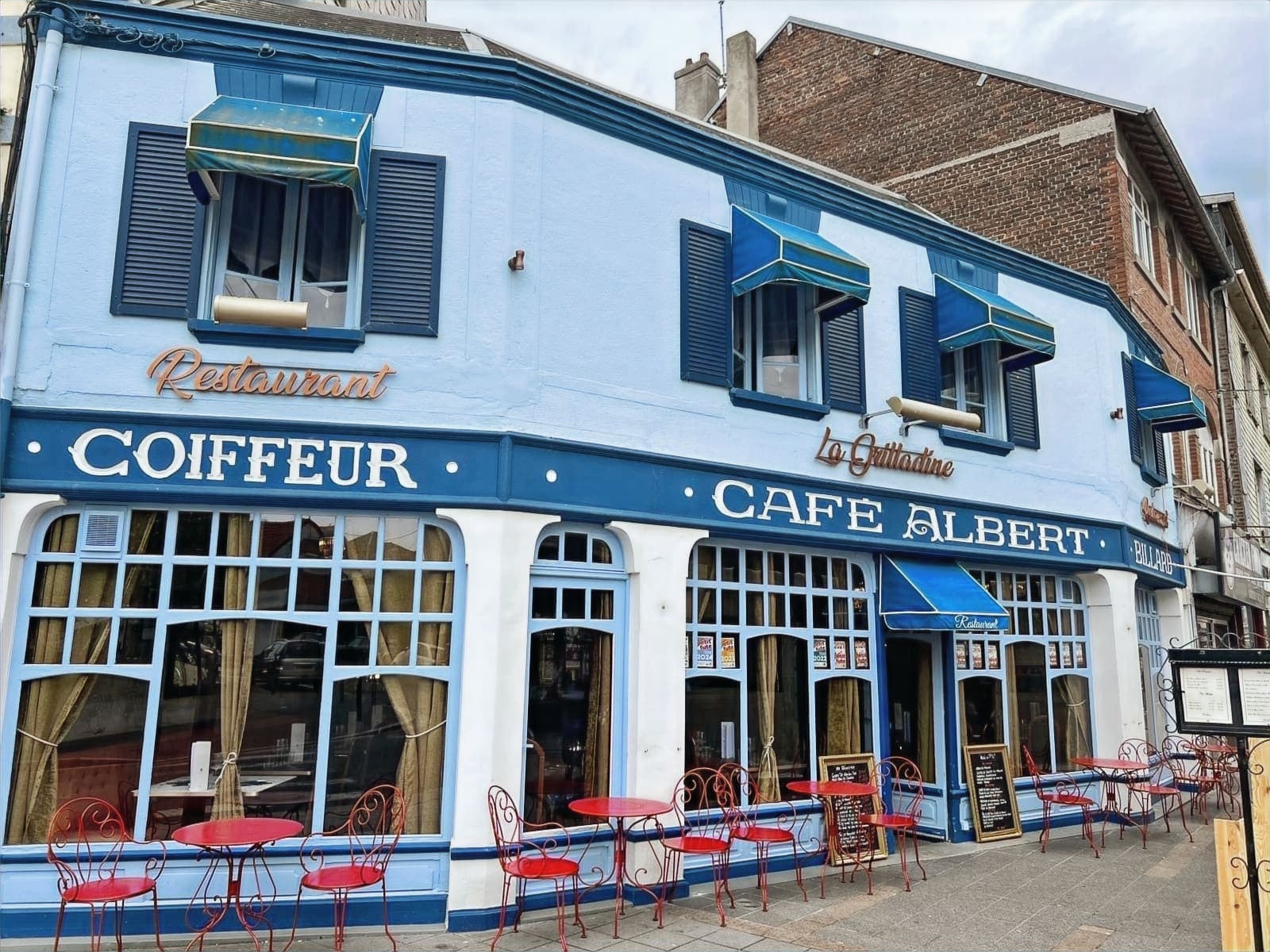 La façade bleue de La Grilladine, rue de Berck, et sa terrasse aux chaises rouges